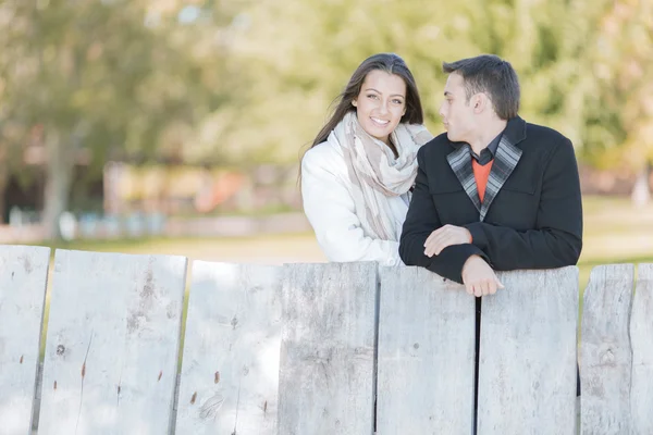 Young couple by the wooden fence — Stock Photo, Image