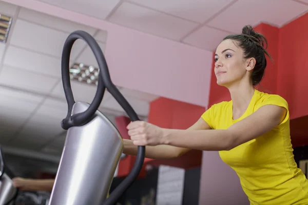 Spor salonunda çalışan genç bir kadın. — Stok fotoğraf