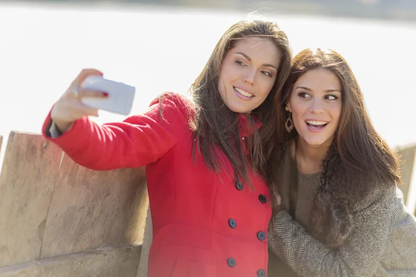 Boldog, fiatal nők fénykép-val mozgatható telefon — Stock Fotó