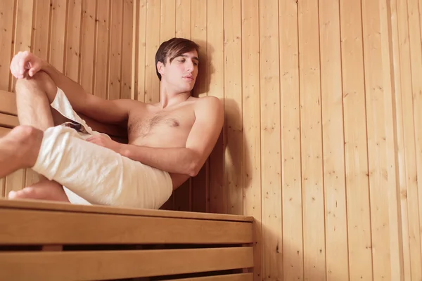 Jonge man ontspannen in de sauna — Stockfoto