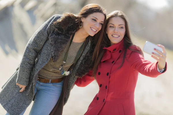 Happy young women taking photo with mobile phone — Stock Photo, Image
