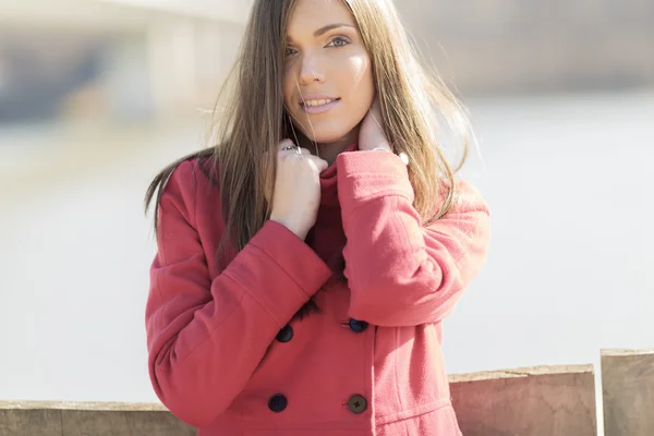 Mooie jonge vrouw in rode jas — Stockfoto