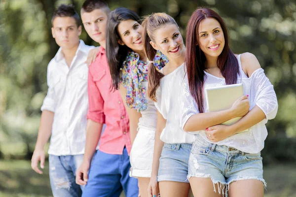 Teenagers in the park with tablet — Stock Photo, Image