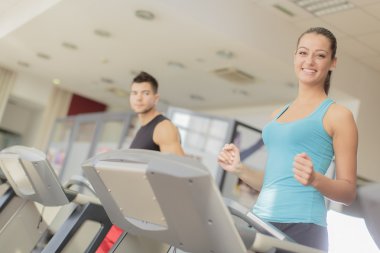 Genç adam ve kadın spor salonunda antrenman yapıyor.