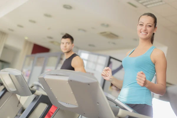 Entrenamiento de hombres y mujeres jóvenes en el gimnasio — Foto de Stock