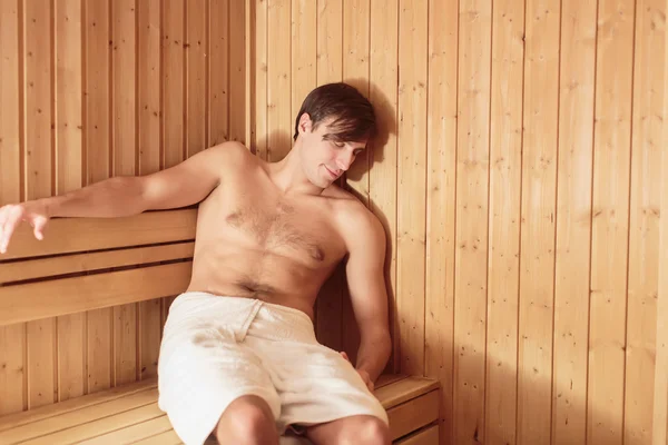 Jeune homme relaxant dans le sauna — Photo