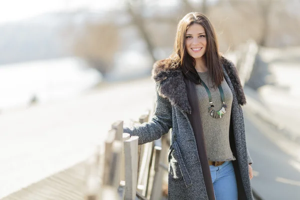 Jonge vrouw door het hek — Stockfoto