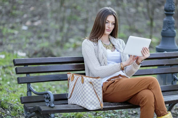 公園にタブレットを持っている若い女性は — ストック写真