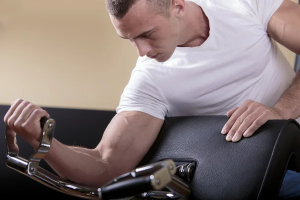 Séduisant jeune homme s'entraînant dans la salle de gym — Photo