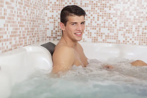 Jonge man ontspannen in de hot tub — Stockfoto