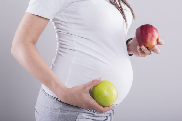 Pregnant woman with apples