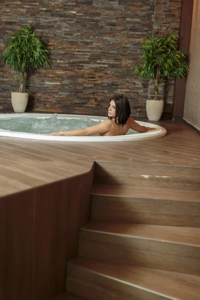 Mujer joven relajándose en la bañera de hidromasaje — Foto de Stock