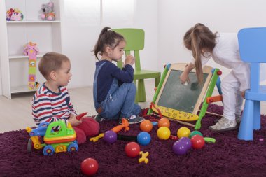 Çocuklar odada oynuyor.