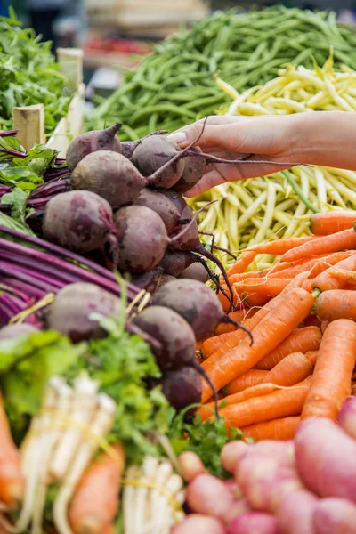 Kvinna köpa grönsaker på marknaden — Stockfoto