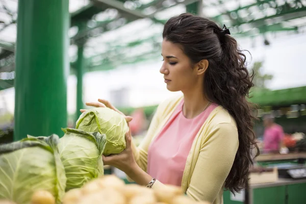 Ganska ung kvinna köpa grönsaker på marknaden — Stockfoto