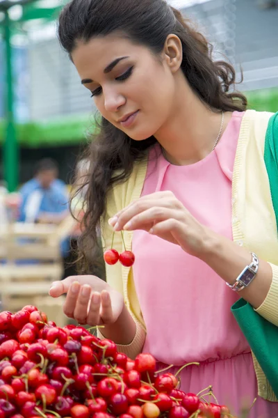 Молодая женщина покупает вишни — стоковое фото