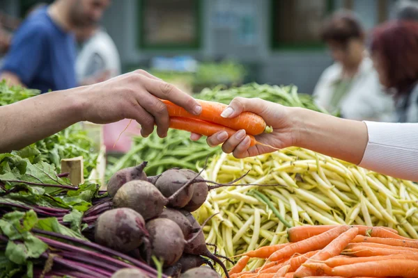 Женщина покупает овощи на рынке — стоковое фото