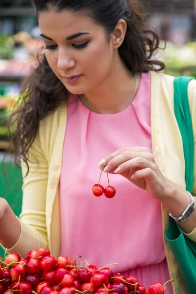 Fiatal nő vásárol cseresznye — Stock Fotó