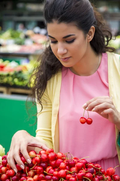 Jeune femme achetant des cerises — Photo