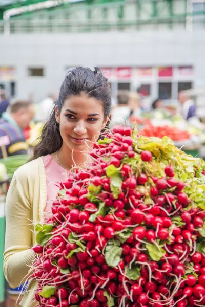 Bella giovane donna che compra verdure sul mercato — Foto Stock