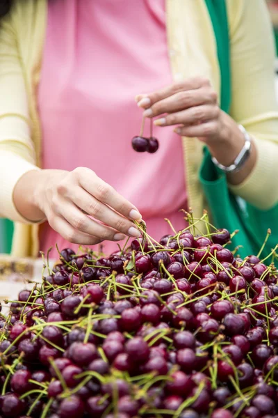 Jovem mulher comprando cerejas — Fotografia de Stock