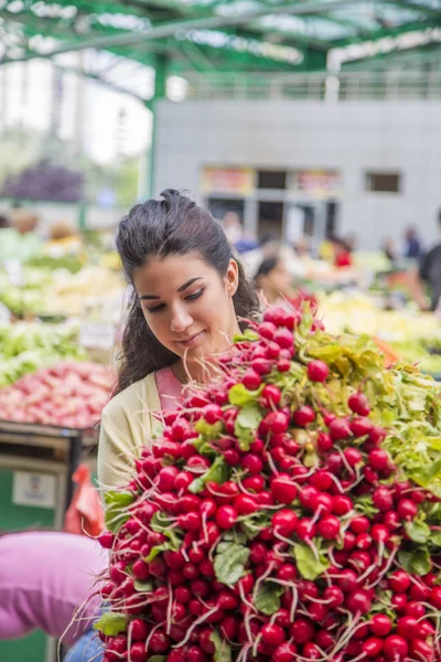 Jolie jeune femme achetant des légumes sur le marché — Photo