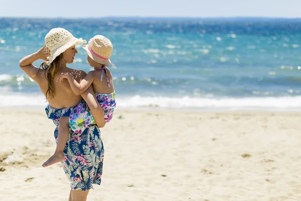 Anne ve kızı sahilde. — Stok fotoğraf