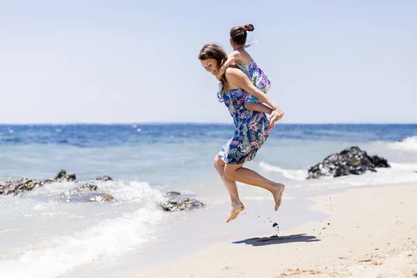 Moeder en dochter op het strand — Stockfoto