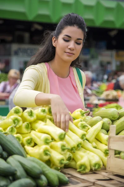 Mooie jonge vrouw fruit op de markt kopen — Stockfoto