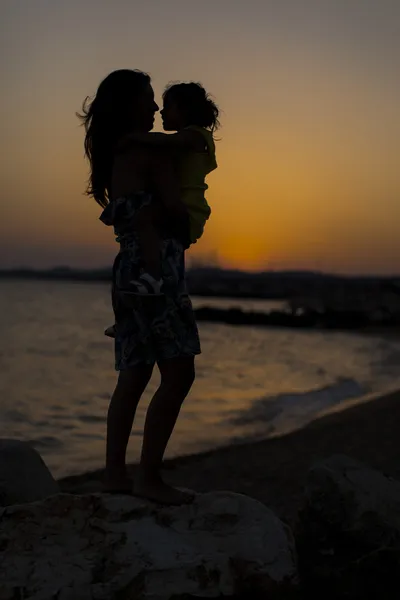Mother and daughter at the beach at sunset — Stock Photo, Image