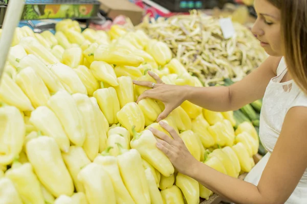 Nuori nainen ostaa vihanneksia markkinoilta — kuvapankkivalokuva