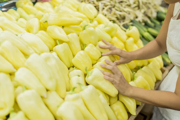 Ung kvinna köpa grönsaker på marknaden — Stockfoto