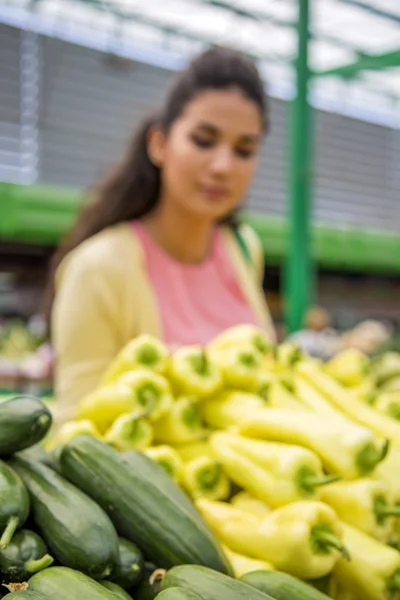 Bella giovane donna che compra verdure sul mercato — Foto Stock