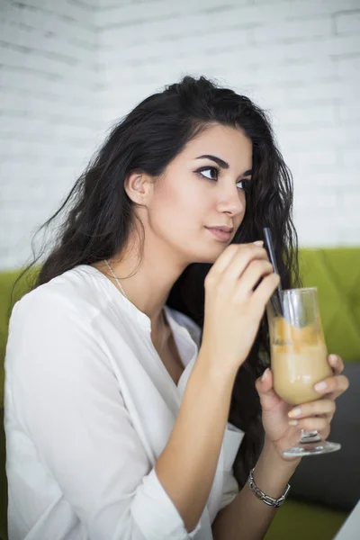 Jonge vrouw die koffie drinkt in café — Stockfoto