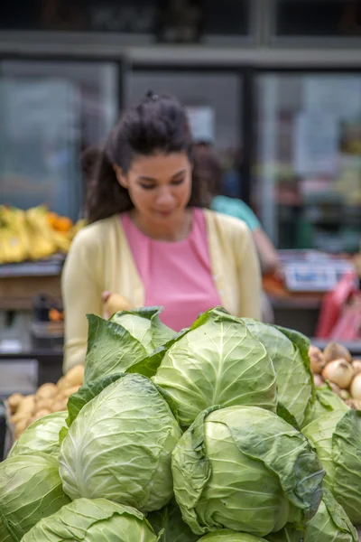 Pretty young woman buying vegetables on the market — Stock Photo, Image