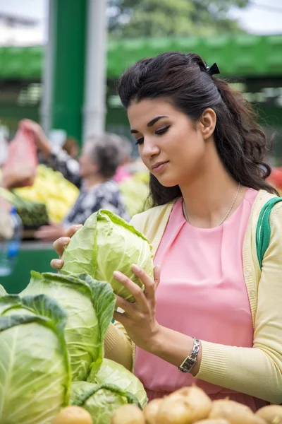 Csinos, fiatal nő vásárol zöldség a piacon — Stock Fotó