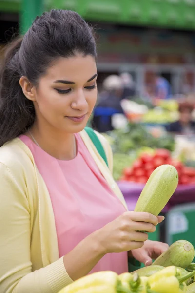 Ganska ung kvinna köpa grönsaker på marknaden — Stockfoto