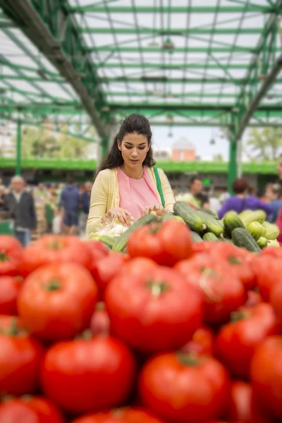 Ganska ung kvinna köpa grönsaker på marknaden — Stockfoto