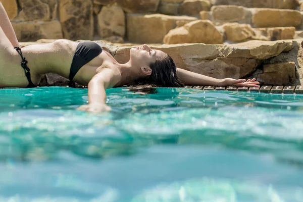 Donna sdraiata vicino alla piscina — Foto Stock