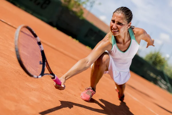 Mladá žena hraje tenis — Stock fotografie