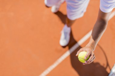 Genç adam tenis oynuyor.