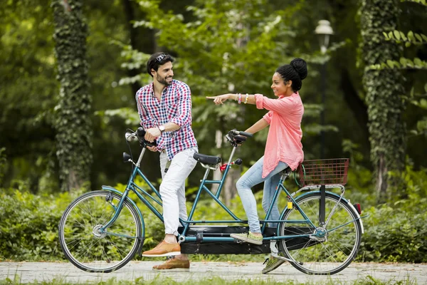 Young couple riding on the tandem bicycle — Stock Photo, Image