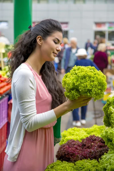 Csinos, fiatal nő vásárol zöldség a piacon — Stock Fotó