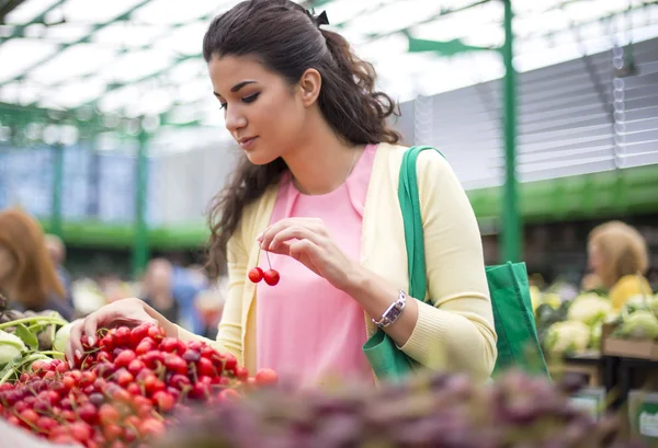 Giovane donna che compra ciliegie al mercato — Foto Stock