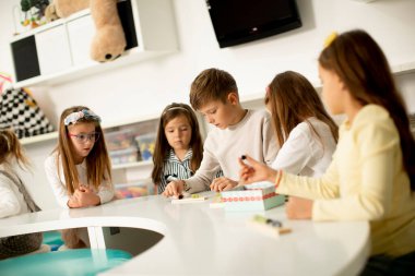 Anaokulu ahşap oyuncaklarıyla oynayan bir grup küçük çocuk.