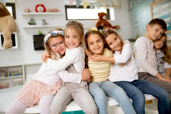 Bir grup şirin anaokulu çocuğu oturup eğleniyor.