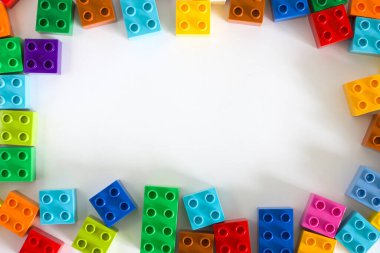 Beyaz zemin üzerinde boş telif alanı olan renkli plastik yapı blokları