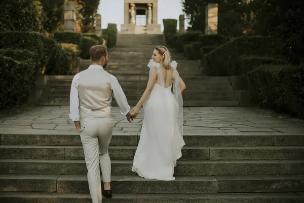 公園の階段を歩いてかわいい若い新婚夫婦の後ろの景色 — ストック写真