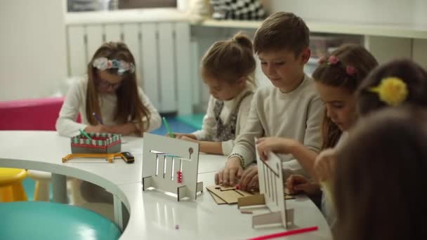 就学前の木製の教育用おもちゃで遊んでいる小さな子供たちのグループ — ストック動画