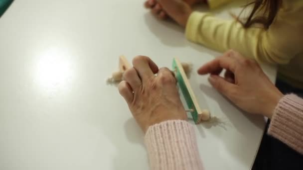 就学前の木製の教育玩具で遊ぶ方法を説明する幼稚園の先生 — ストック動画